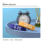 Blue and yellow Brynk Wake wristbands next to an alarm clock – the band wakes only you with vibration